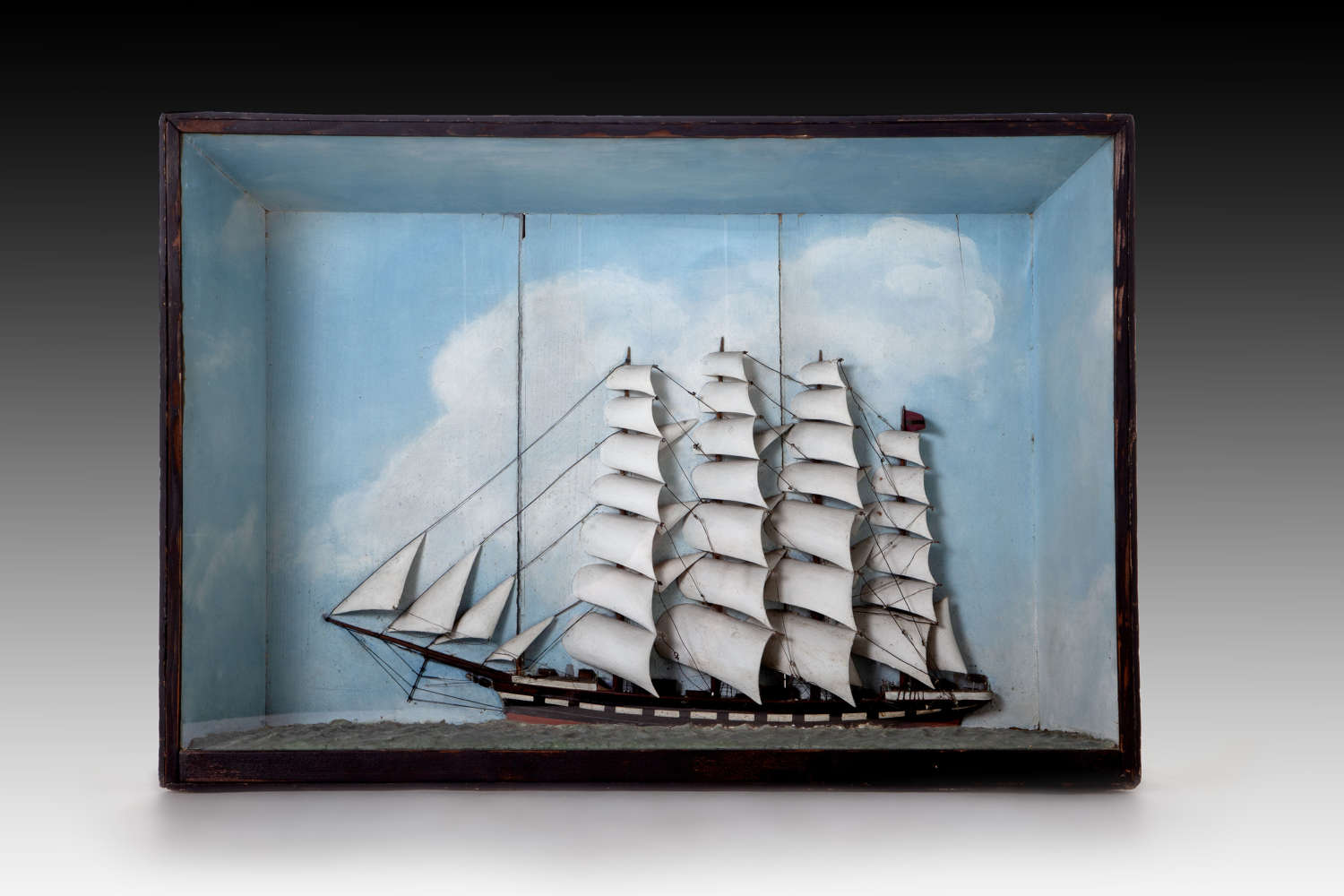 A very large diorama of a ship in full sail on a bright day