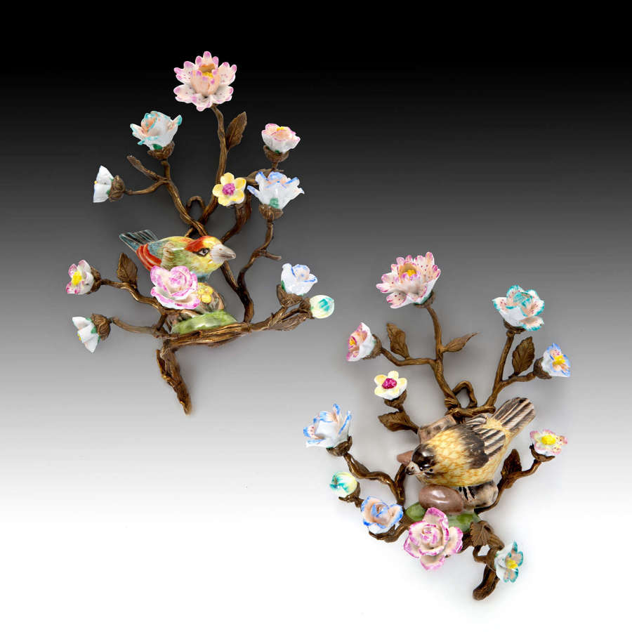 A pair of bronze and porcelain wall appliques