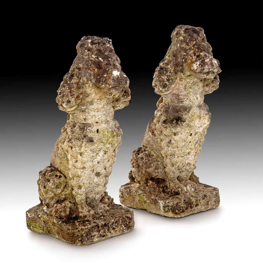 A pair of carved limestone poodles